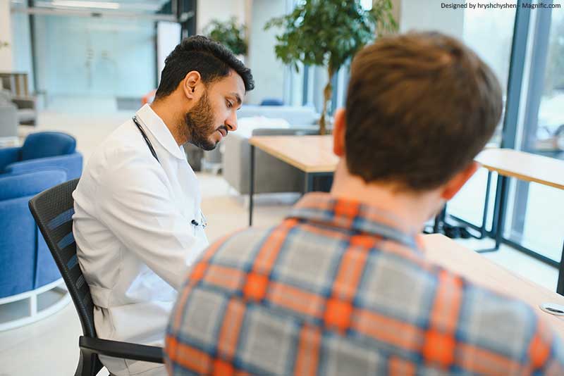 zwei Männer sitzen am Schreibtisch und arbeiten
